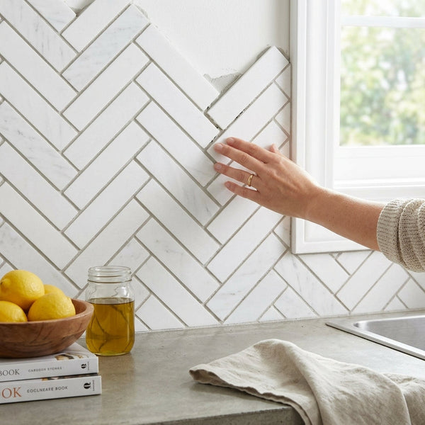 Thassos white 1x4 herringbone mosaic polished marble tiles in white used as a kitchen backsplash