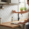 White subway tile backsplash with subtle gray veining made of Thassos white 2x4 deep-beveled brick mosaic marble polished honed