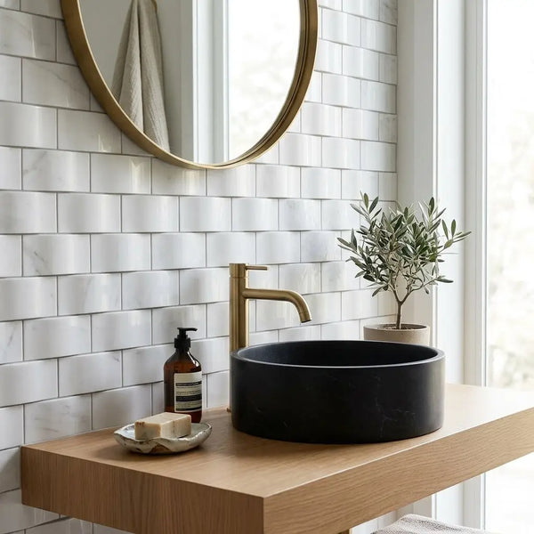 Black matte stone vessel sink with a sleek modern design paired with Thassos white 2x4 round-faced mosaic marble polished or honed