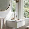 White marble bathroom vanity with sleek modern design and integrated storage drawer featuring thassos white 2x4 straight-edged brick mosaic marble