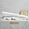 A sleek cylindrical white marble thassos white 3/4x12 bullnose liner polished rod on hexagonal and rectangular tiles