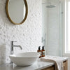 White ceramic vessel sink with sleek chrome faucet on marble countertop featuring Thassos white mini-brick mosaic tile