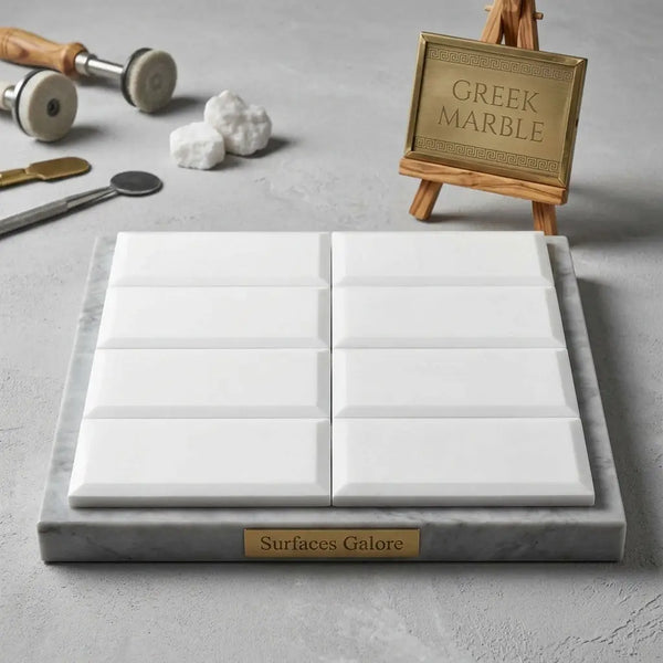 Thassos White 3x6 deep-beveled white greek marble polished-honed tiles arranged in a grid on gray marble base