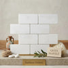 Thassos white 3x6 marble tumbled white rectangular greek marble tiles arranged in a stacked brick pattern