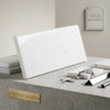 A sleek polished white Thassos marble tile with subtle veining in a 4x12 rectangular single-edge bullnosed shape