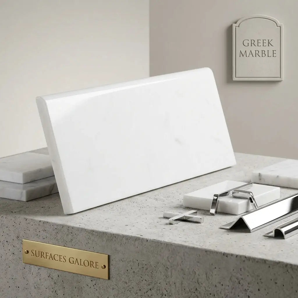 A sleek polished white Thassos marble tile with subtle veining in a 4x12 rectangular single-edge bullnosed shape