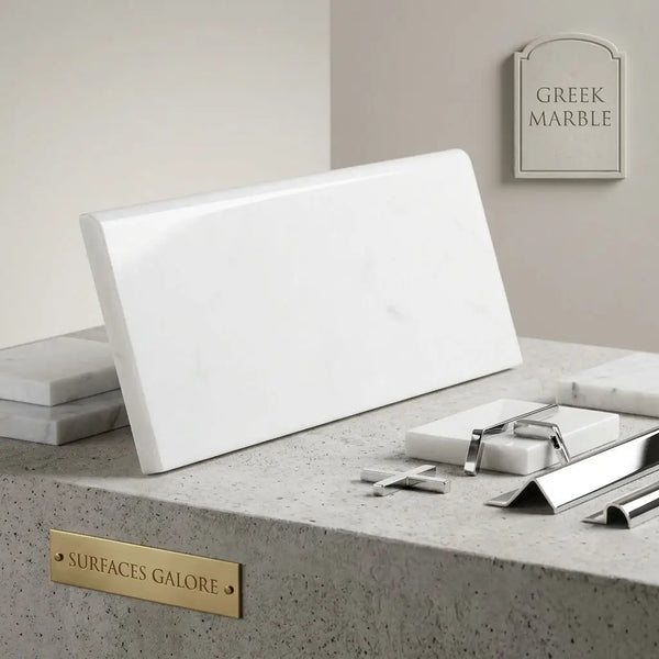 A sleek polished white Thassos marble tile with subtle veining in a 4x12 rectangular single-edge bullnosed shape