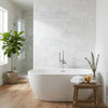 White freestanding bathtub with smooth glossy finish featuring thassos white 4x12 marble polished or honed tiles