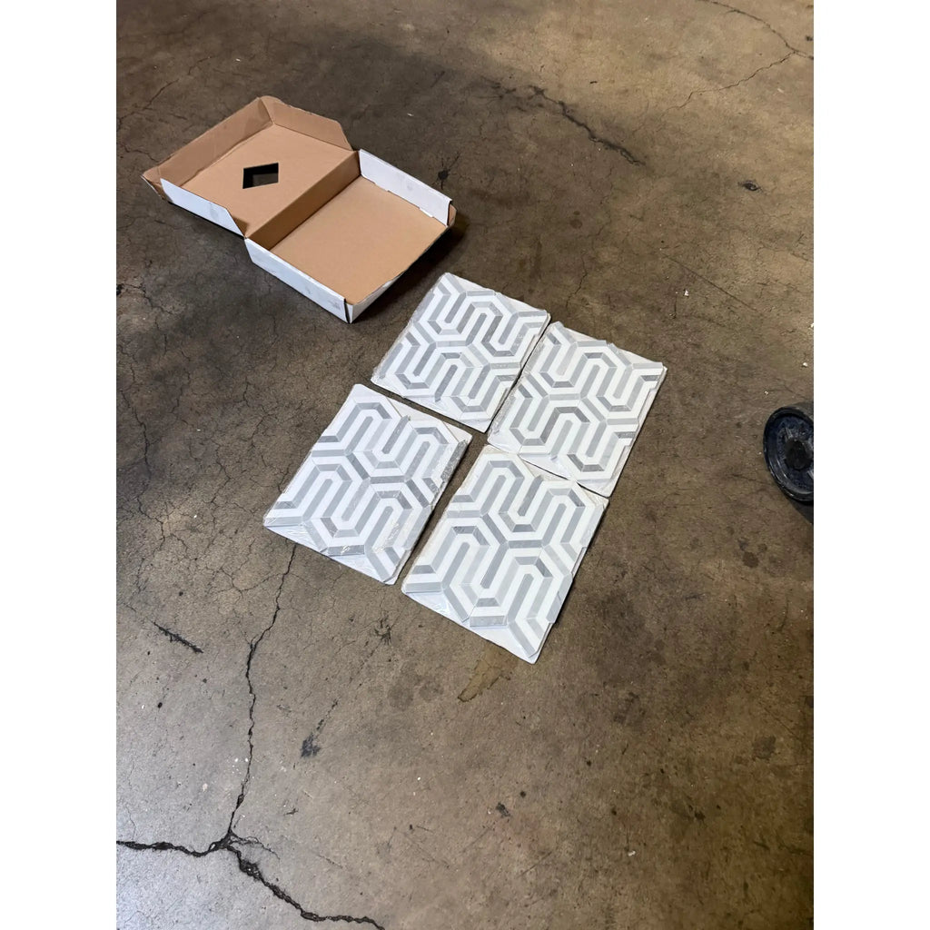 Patterned Thassos White Berlinetta mosaic marble tiles with a cardboard box display
