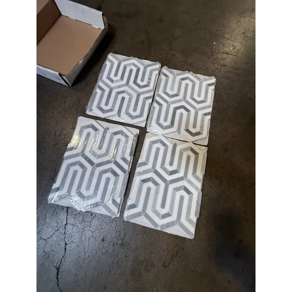 Four geometric patterned Thassos White Berlinetta Design mosaic marble tiles with blue-gray accents