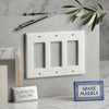White marble three-gang rocker switch plate with polished thassos marble finish and subtle veining wall cover