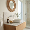 White ceramic vessel sink with a smooth rounded bowl shape on a polished thassos white penny-round marble countertop