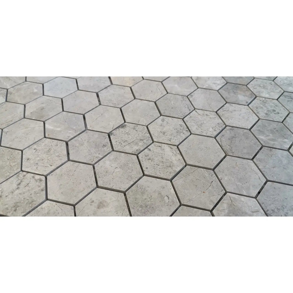 Gray hexagonal marble mosaic tiles in tundra gray with subtle veining and a matte honed finish for flooring or walls