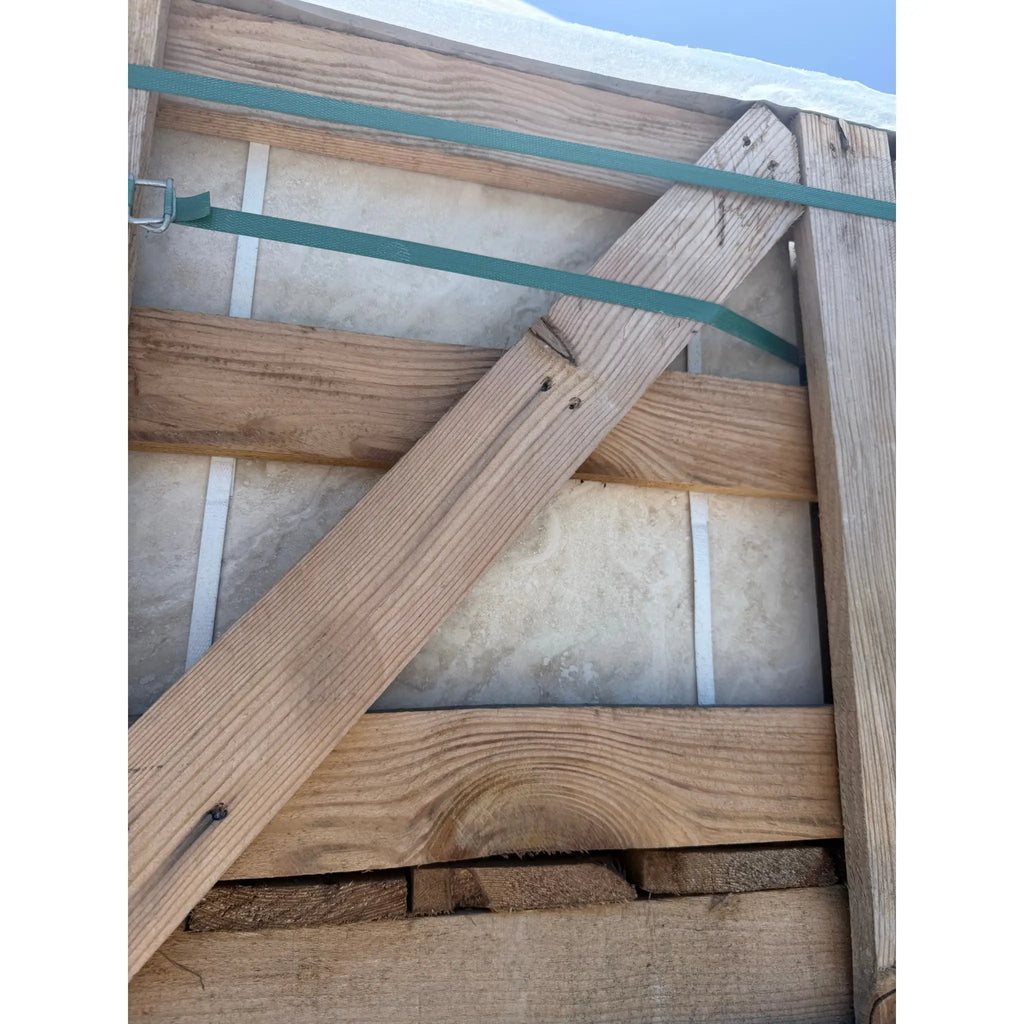 Wooden crate with green straps containing Valencia Travertine 18x18 filled and honed tiles