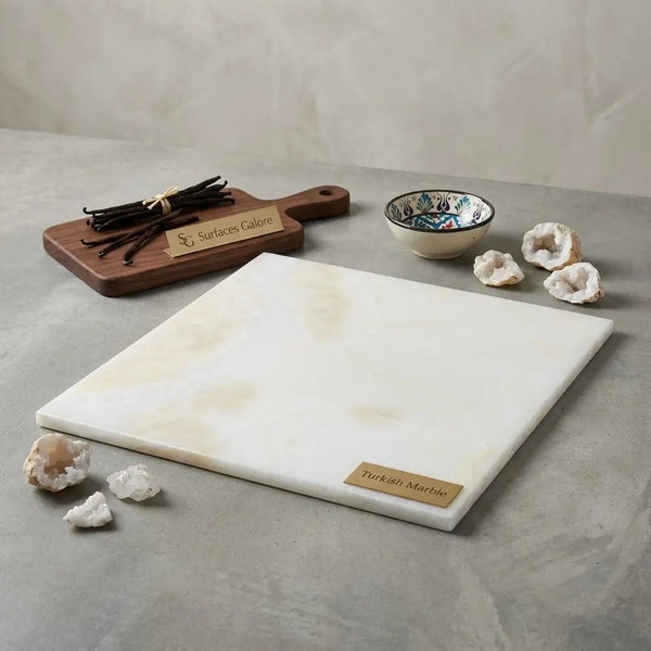 A sleek white onyx cross cut 18x18 marble cutting board with a smooth surface and subtle beige veining