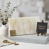 A rectangular polished white onyx vanilla onyx cross cut marble slab with creamy beige color and subtle golden veining on gray base