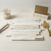 White onyx random-strip polished marble tile featuring white turkish marble with subtle veining in a staggered pattern