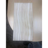 Rectangular light-colored tile with vertical wavy patterns from White Onyx Vein-Cut Marble