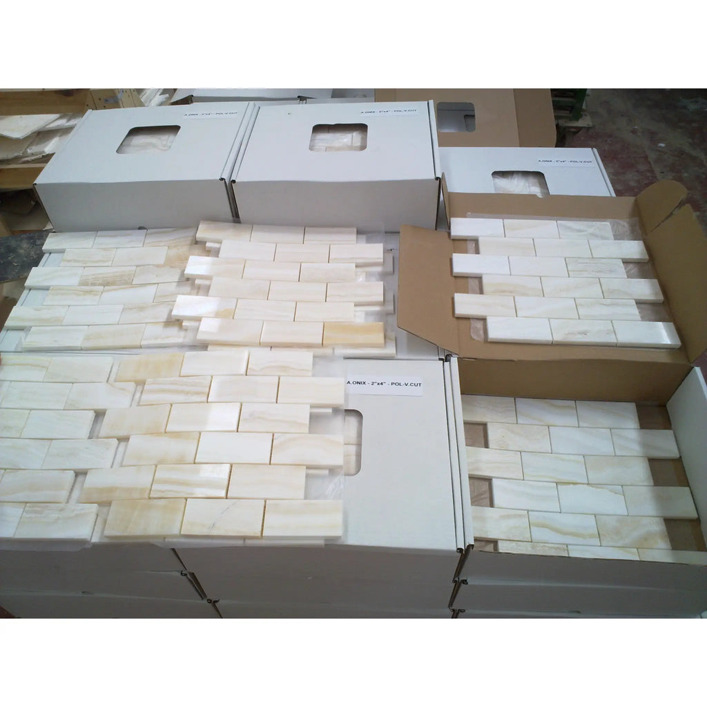 Beige and cream-colored polished white onyx vein-cut 2x4 marble mosaic tiles with natural veining in staggered brick layout