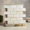 A sleek cream-colored polished white onyx vein-cut 2x4 mosaic marble tile sample with subtle veining in brick pattern