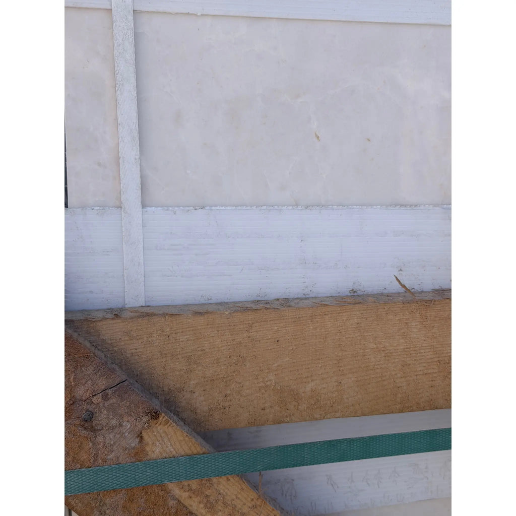 Beige and white white pearl botticino marble wall panel with textured surface vertical seams and horizontal trim