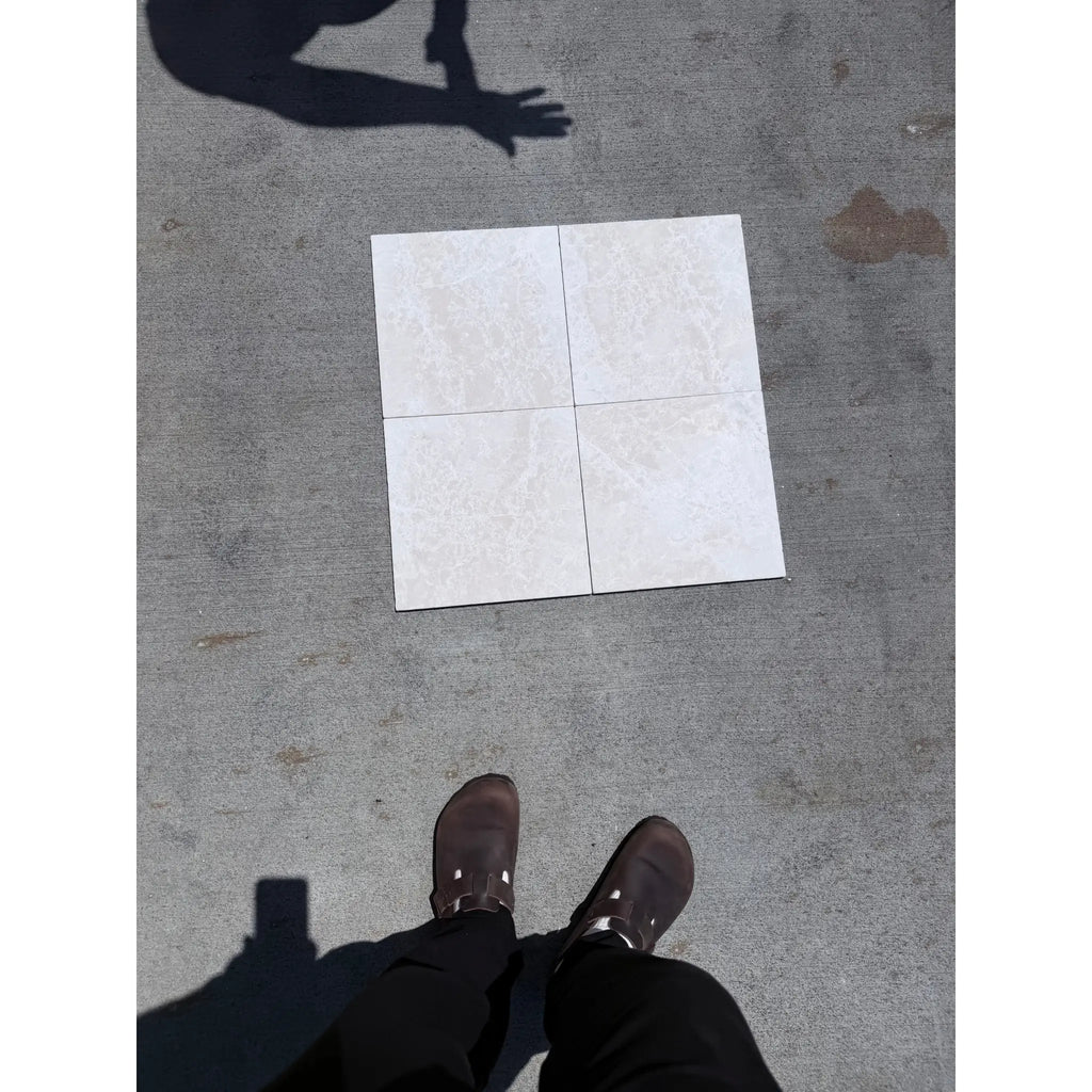 Four off-white white pearl botticino beige marble ceramic tiles arranged in a 2x2 grid with tumbled finish