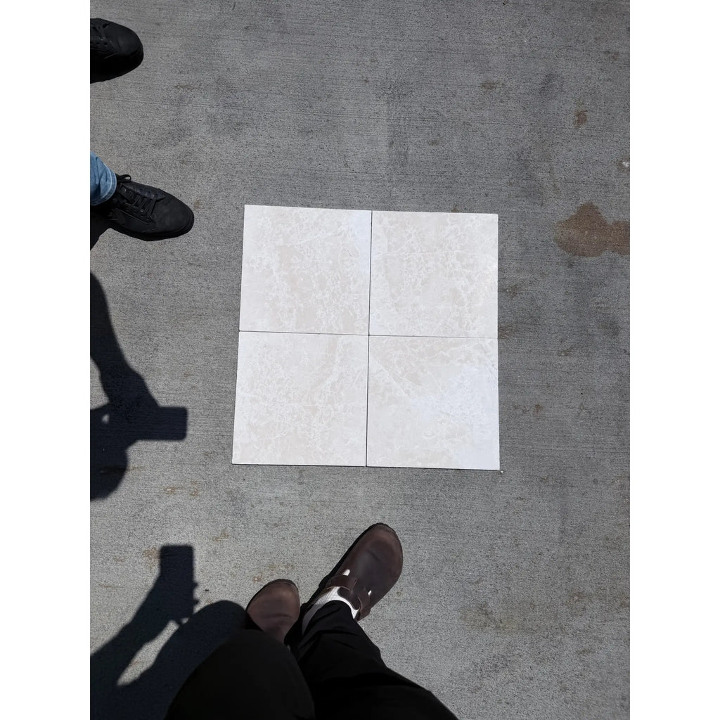 Four off-white white pearl botticino beige marble 12x12 tumbled ceramic tiles with subtle marbled texture in 2x2 grid