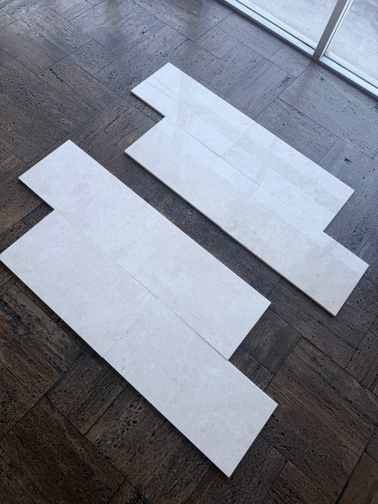 White Pearl Botticino Beige marble 12x24 polished tiles with subtle veining on dark floor