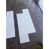 White Pearl Botticino Beige marble 12x24 tiles with subtle veining on dark wood floor