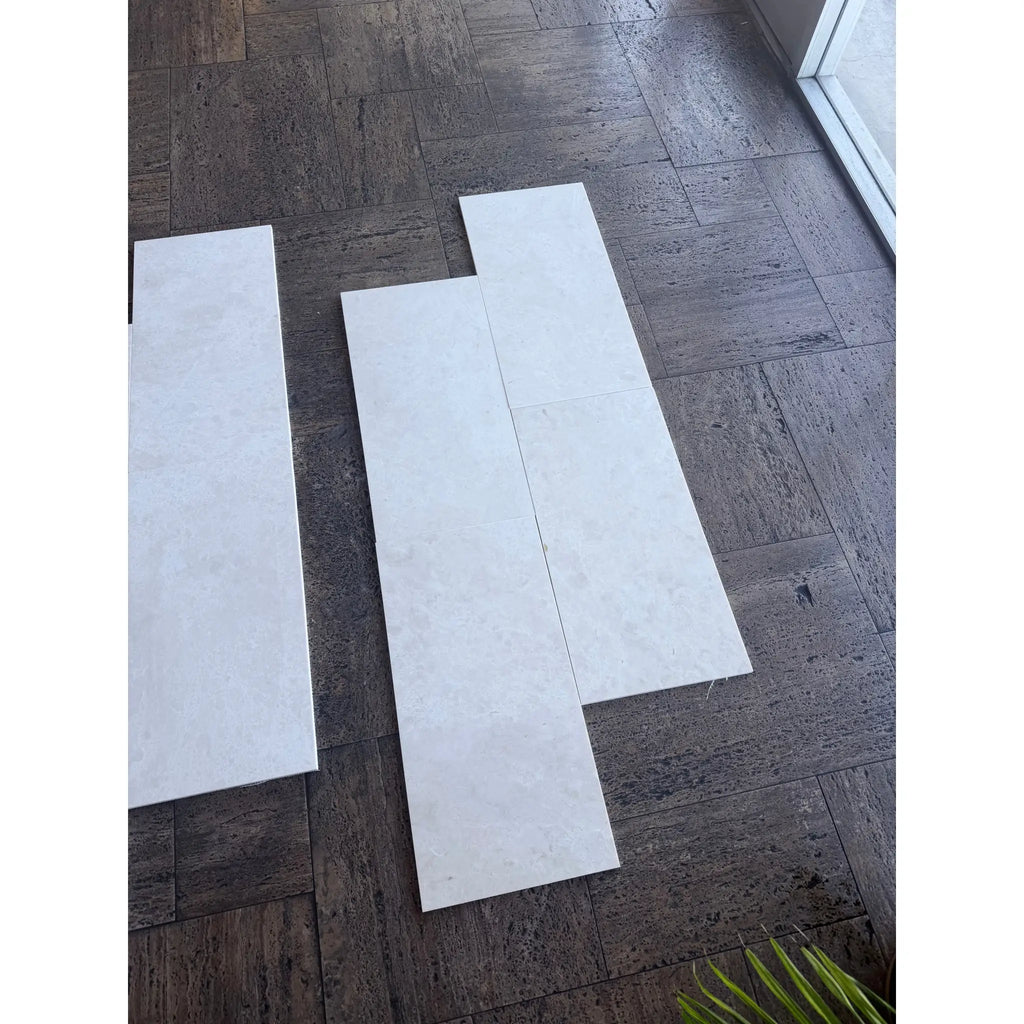 White Pearl Botticino Beige marble 12x24 tiles with subtle veining on dark wood floor
