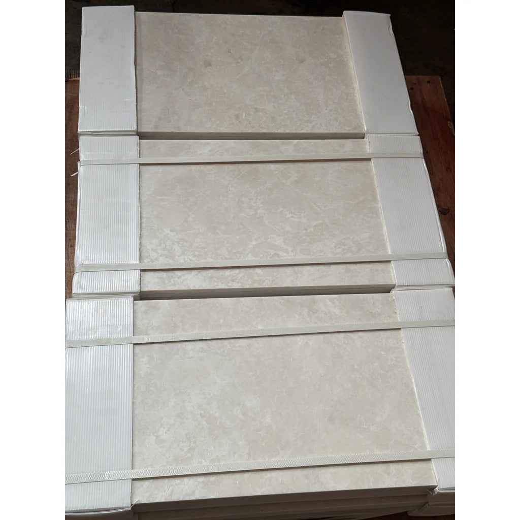 Stacked White Pearl and Botticino Beige Marble 12x24 tiles with protective packaging