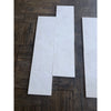 Three White Pearl marble 12x24 tiles with marbled texture on wood floor