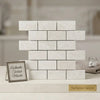 White pearl botticino beige marble 2x4 brick mosaic polished tiles arranged in a classic brick pattern