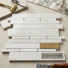 White pearl botticino beige marble tiles arranged in staggered horizontal pattern with subtle veining polished finish